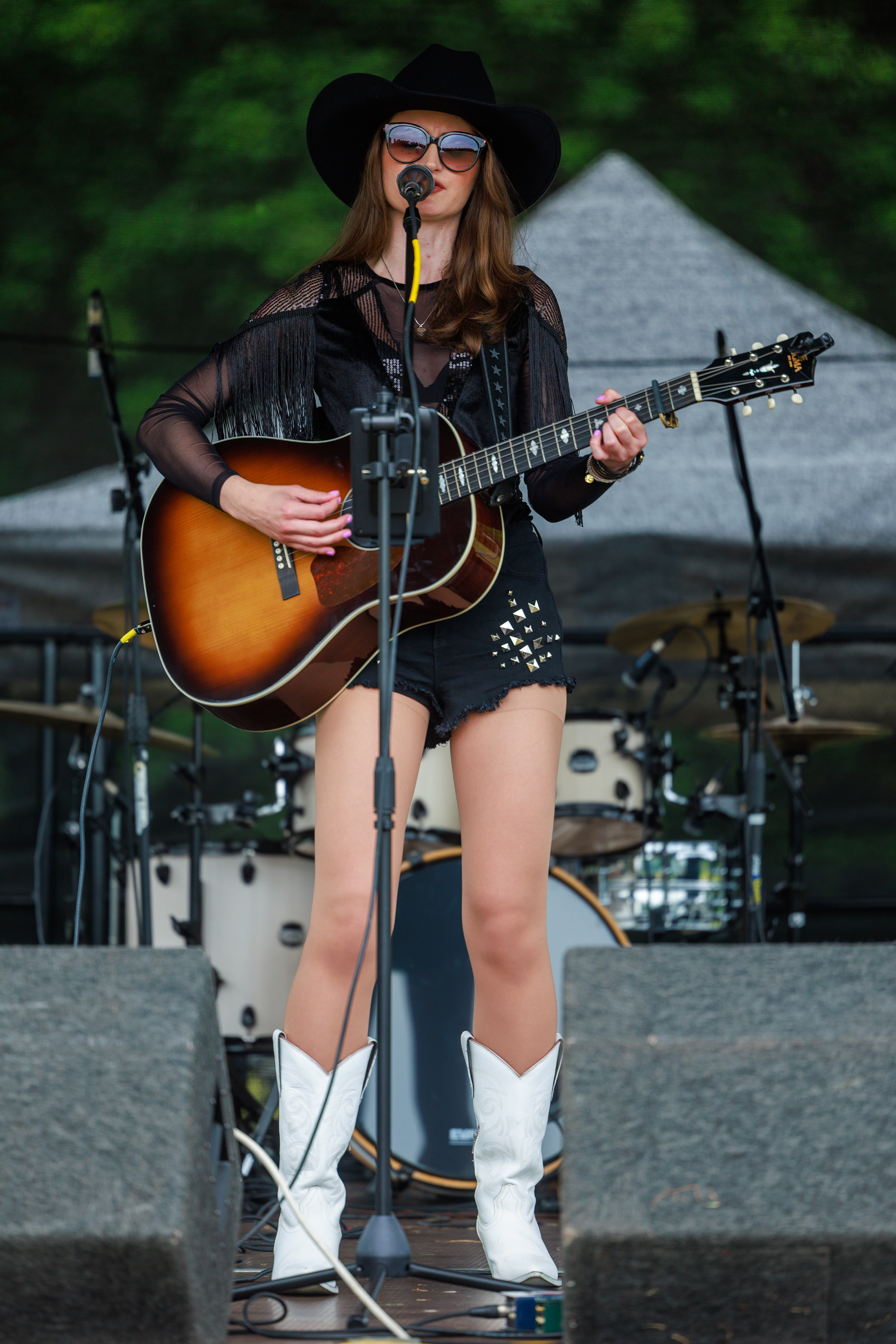 Female guitarist, standing by microphone singing and playing a guitar